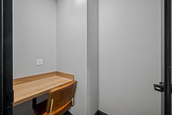 a small desk in a room with a chair